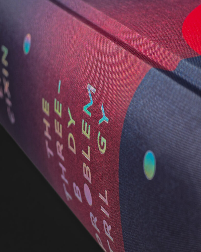 Close-up of the printed Setalux cloth and holographic silver lettering on The Three-Body Problem Trilogy.