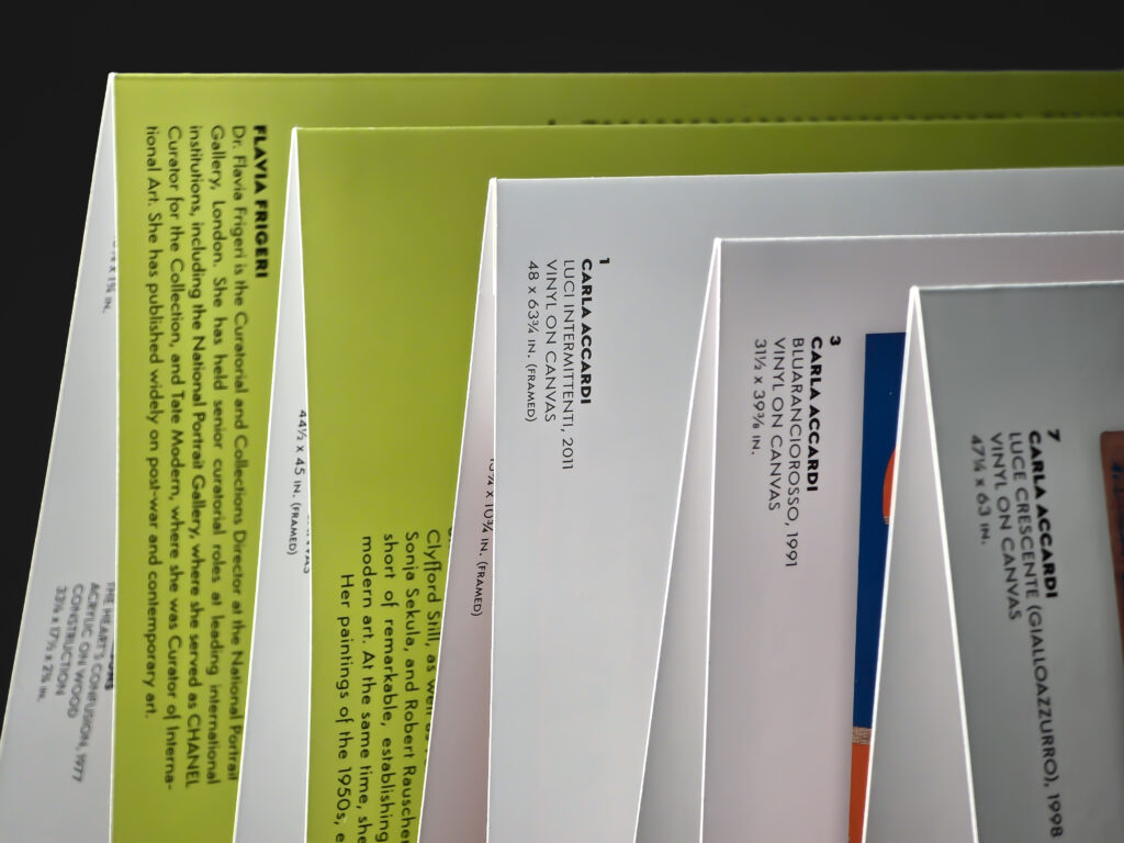 Close-up of the folded catalogue structure, showing artwork captions, printed panels and the alternating accordion folds.